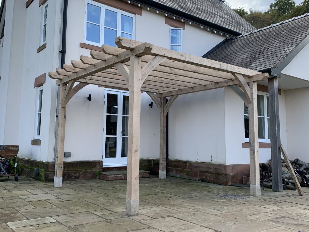 green oak timber framed pergola next to house