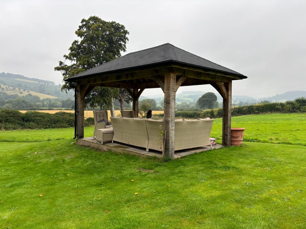 roofed gazebo in garden viewed from the back right
