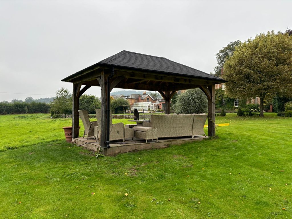 roofed gazebo in garden viewed from the back left